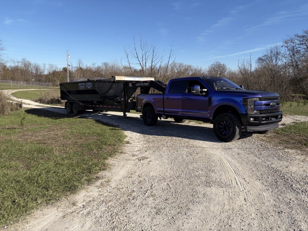 Diamond Dumpsters & Dirtworks truck hauling a roll-off dumpster
