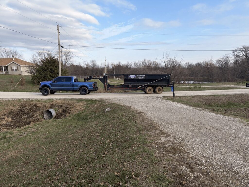 Diamond Dumpsters & Dirtworks truck hauling a roll-off dumpster