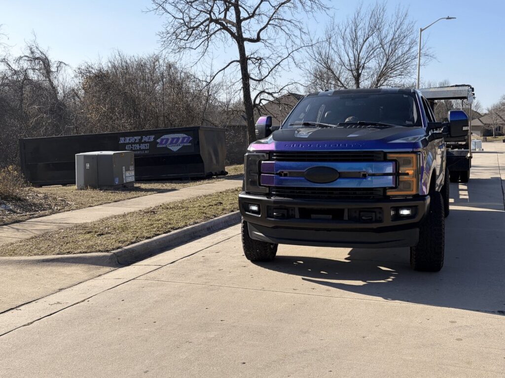 Diamond Dumpsters & Dirtworks truck hauling a roll-off dumpster